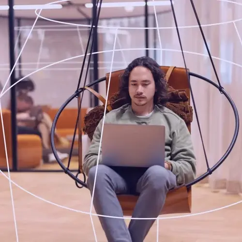 employee working in hybrid workplace in a round chair employee working in hybrid workplace in a round chair